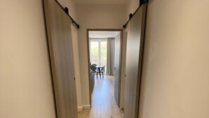 En hall med trägolv och skjutdörrar på båda sidor.