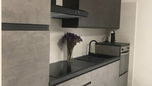 Een moderne keuken met een zwart aanrecht, grijze kastjes en een ingebouwde oven.