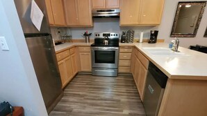 Una cocina moderna con armarios de madera, electrodomésticos de acero inoxidable y una isla central.