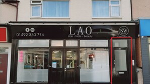 Fachada de un local con un letrero que dice "LAO Hair - Nails - Beauty" y un número de teléfono.