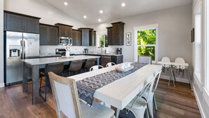 Una cocina moderna con armarios de madera oscura, electrodomésticos de acero inoxidable y una isla central con taburetes.