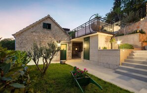 A stone house with a balcony, a small garden, and a staircase leading to an upper level. - Cozy home in Donji Prolozac (Donji Prolozac)
