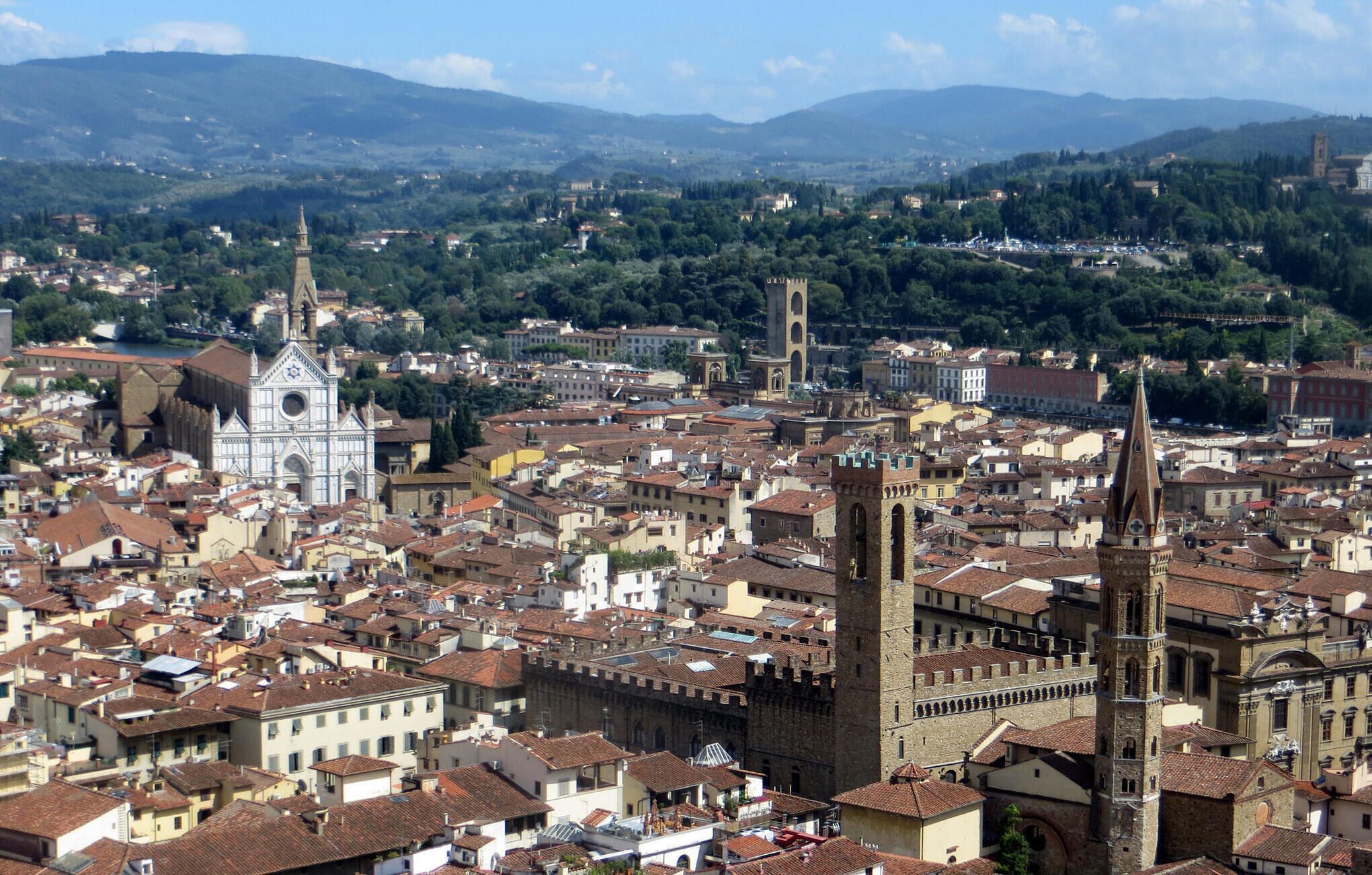 A densely packed urban area with historic architecture, including a prominent church with a tall bell tower and a fortified building with a round tower.