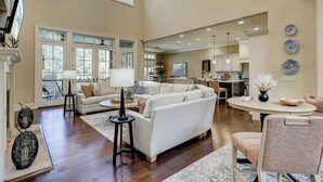 A spacious living room with a large sofa, a dining area with a round table, and a kitchen in the background. - 13 Wagon Rd. Vacation paradise! Close to the beach! Water view! (Hilton Head Island)