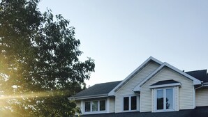 Een tweelaags huis met een voortuin, een garage en een verzorgd gazon.