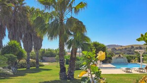 A pool area with palm trees, a pergola, and a view of hills in the background. - Gorgeous home in Rosolini (Rosolini)