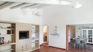 A spacious living area with a fireplace, white walls, and a dining area with a table and chairs. - Gorgeous home in Rosolini (Rosolini)