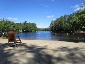Enjoy a serene lakeside setting with a clear view of the water, surrounded by lush greenery.