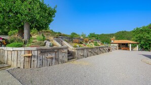 Une clôture en bois avec une pancarte indiquant « Appartements », qui mène à un chemin de gravier.