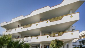 Un edificio de varios pisos con techo plano y balcones.