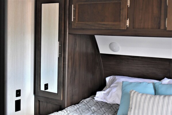 A bedroom with a bed, pillows, and a window.