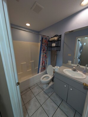 A bathroom with a bathtub, toilet, and sink.