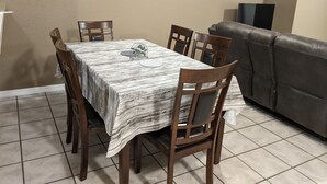 A dining area with a table covered by a striped tablecloth, surrounded by wooden chairs. - Snowbirds escape / vacation gateway (Englewood)