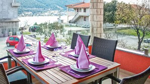 A dining table set with purple napkins, black chairs, and a view of a town and mountains in the background. - Gorgeous apartment in Grebastica with WiFi (Grebastica)