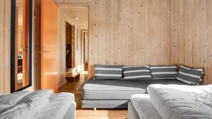 Una habitación con una cama, dos mesitas de noche y suelo de madera.