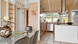 Une cuisine moderne agrémentée de touches de bois, un coin repas avec une carte et une vue sur l’extérieur.
