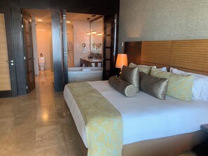Relax in a spacious room with a large bed, wooden headboard, and a bathroom with a toilet, sink, and mirror.