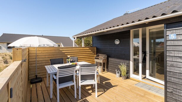 A wooden deck with a table and chairs, a grill, and a potted plant. - Lovely home in Thisted with WiFi (Thisted)