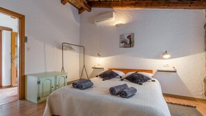 A bedroom with a bed, a wardrobe, a drying rack, and two wall-mounted lights.