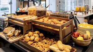 Un bufé de desayuno con diversos pasteles, frutas y bebidas.