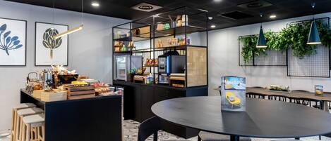 A modern kitchen with a central island, bar stools, and a round table with chairs.