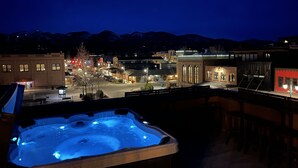 A hot tub with a view of a town at night.