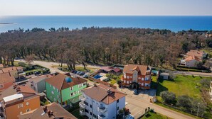 Un quartiere residenziale con case, una strada e vista sul mare.