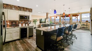 A modern kitchen with a central island, bar stools, and a view of the mountains. - Relaxing, comfortable home for entertaining or enjoying the view (Rio Rancho)