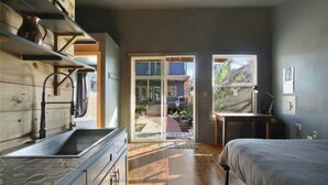 Ein Schlafzimmer mit Bett, Schreibtisch und Fenster.
