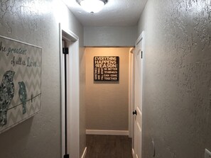 A hallway with a motivational quote on the wall and a door leading to another room. - Mystic Manor Monroe 4 Bed Farm House- 10 min walk to Hot springs (Monroe)