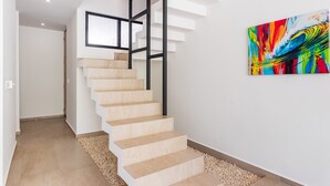 A modern staircase with a minimalist design, a painting on the wall, and a clean, uncluttered space. - Retreat into Exotic Paradise in Riviera Maya, 15 minute walk to beach (residencial El Cielo, Solaridad)