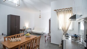 Un espace de vie compact comprenant un coin repas, une kitchenette et un petit coin salon.