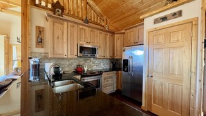Una cocina con armarios de madera, un refrigerador de acero inoxidable, un microondas y una estufa.