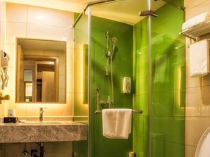 Une salle de bain avec une douche aux carreaux verts, un lavabo avec un miroir et un porte-serviettes.