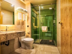 Une salle de bain moderne avec une douche à parois de verre, un comptoir en marbre et des toilettes.