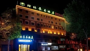 Un hôtel à plusieurs étages, doté d’une enseigne lumineuse et d’une façade bien éclairée.