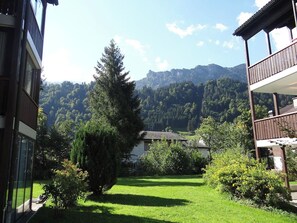 Ein Wohngebiet mit Bergblick, einer Rasenfläche und einem Gebäude mit Balkon.