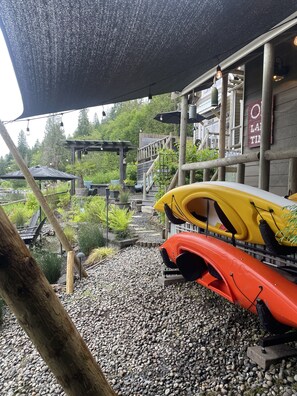 Un espace extérieur abrité avec des kayaks et une terrasse en bois.