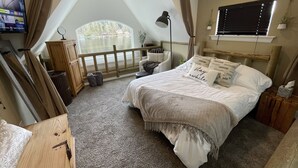 A bedroom with a bed, a TV, a window, and a view of a lake. - Lakefront Cabin in Eatonville, WA (Eatonville)