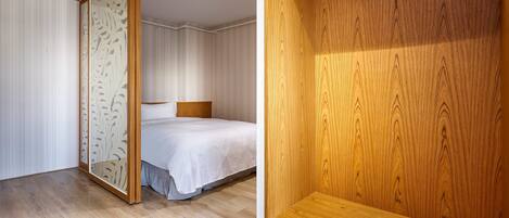 Un dormitorio con cama, suelo de madera y armario de madera.