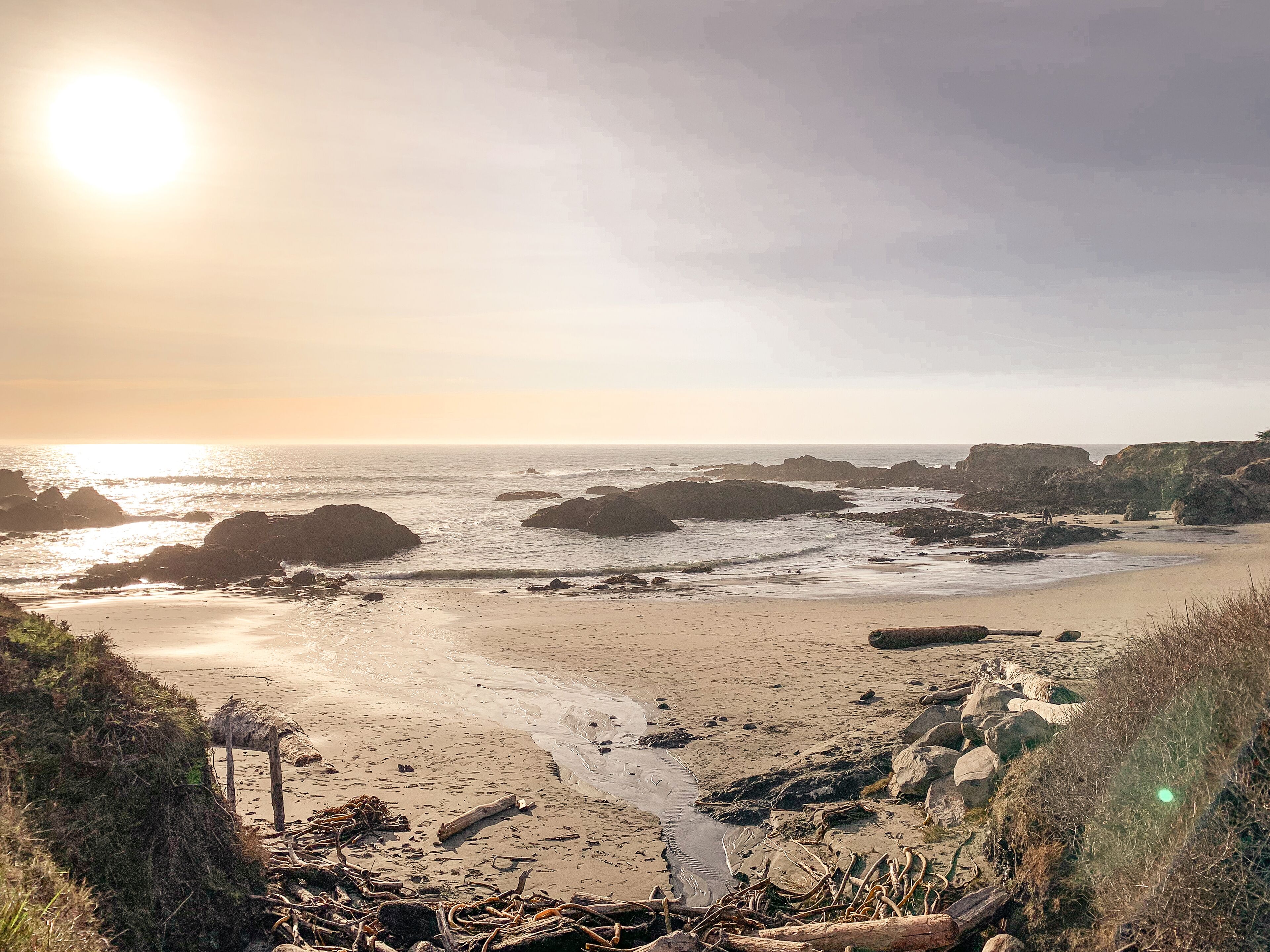 A beach with rocky outcrops and a sandy shore.