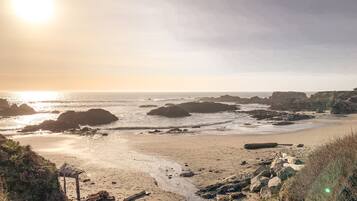 A beach with rocky outcrops and a sandy shore.