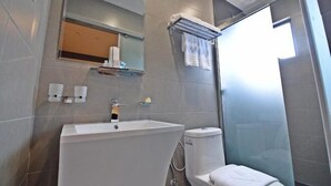 A modern bathroom with a large sink, toilet, and a glass shower enclosure. - Diamond Inn (Kota Kinabalu)