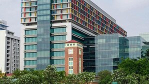 A modern building with multiple floors, large windows, and a mix of glass and brick facade. - Papermoon (Bangkok)