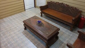 Een kamer met een kamer met een patroon vloer, een houten bankje en een bijpassende salontafel.