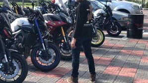 A man standing among motorcycles parked outdoors. - Swiss-belexpress Nilai (Nilai)