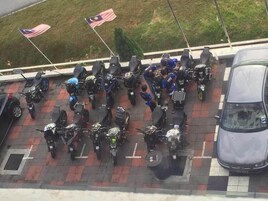 Un área de estacionamiento con varias motocicletas y un coche.