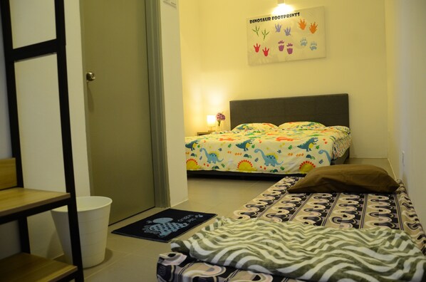 A bedroom with a bed, a bedside table, a chair, and a wall decoration.