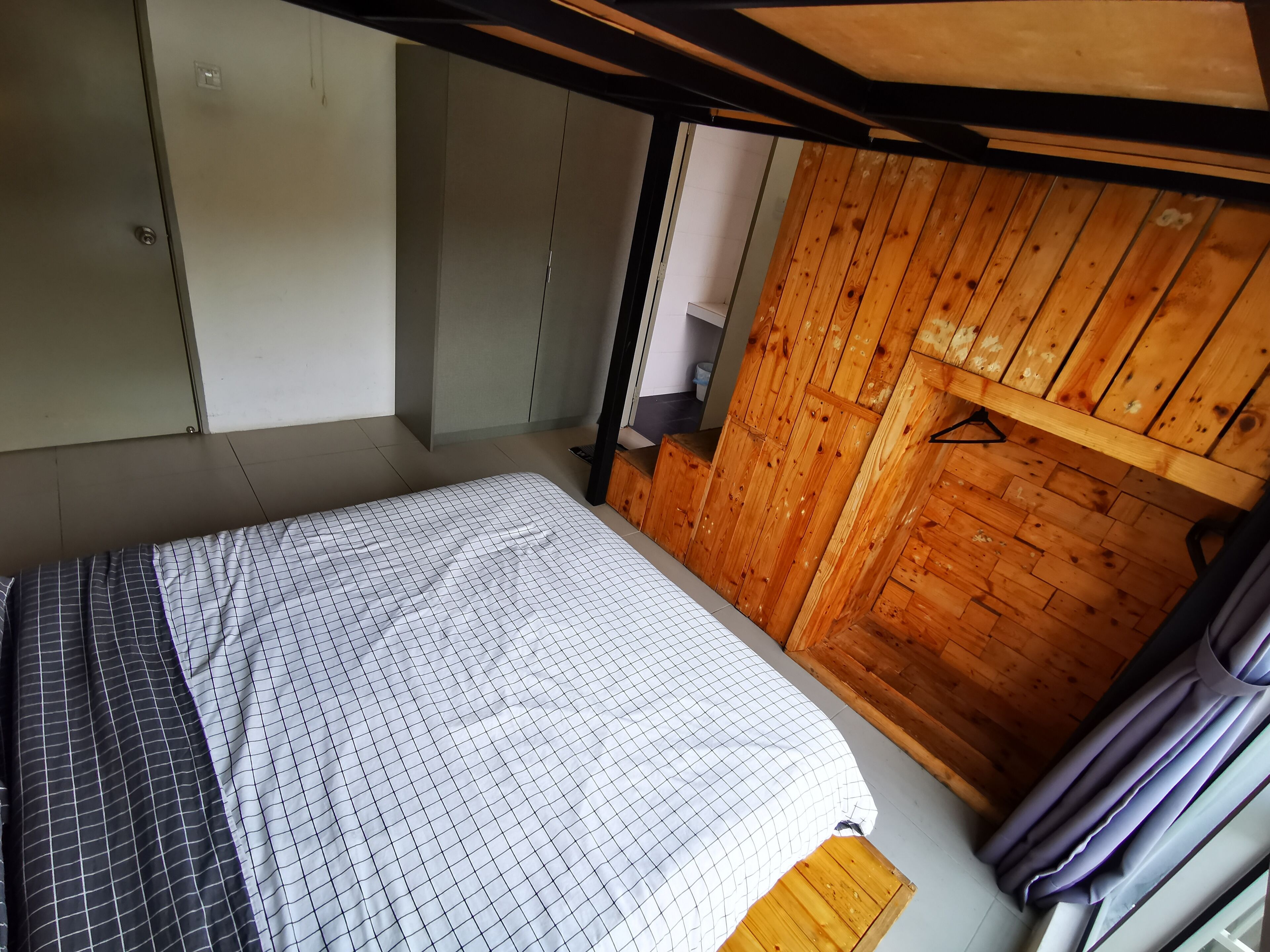 Una camera da letto con un letto a castello, pareti in legno e un angolo con scrivania.