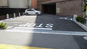 A parking area with a white car parked in a designated spot marked with 'STOP' and 'S'. - Toyoko Inn Akabane-eki Higashi-guchi (Tokyo)